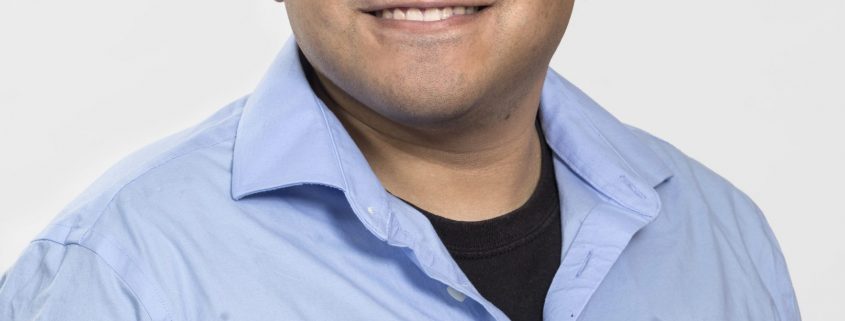Staff headshot of Richard, a Man in blue shirt with dark hair and glasses