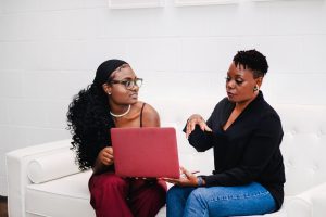 Two women sitting discussing a laptop